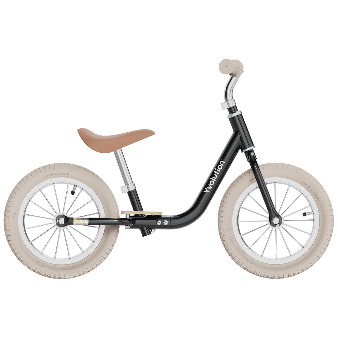 Yvolution loopfiets voor peuters, zwart met bruin zadel en crèmekleurige banden, van de zijkant.