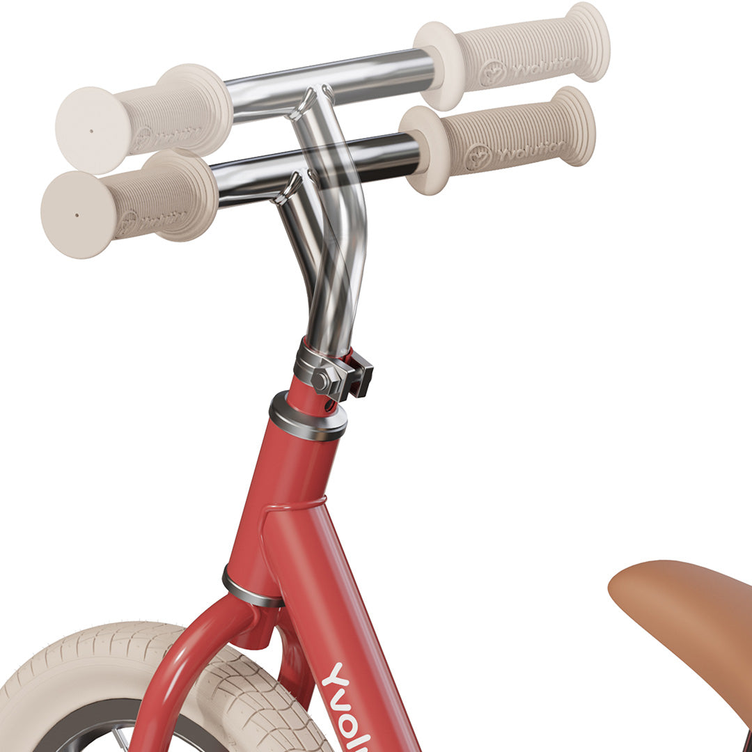 Detail van het verstelbare stuur van de rode loopfiets.