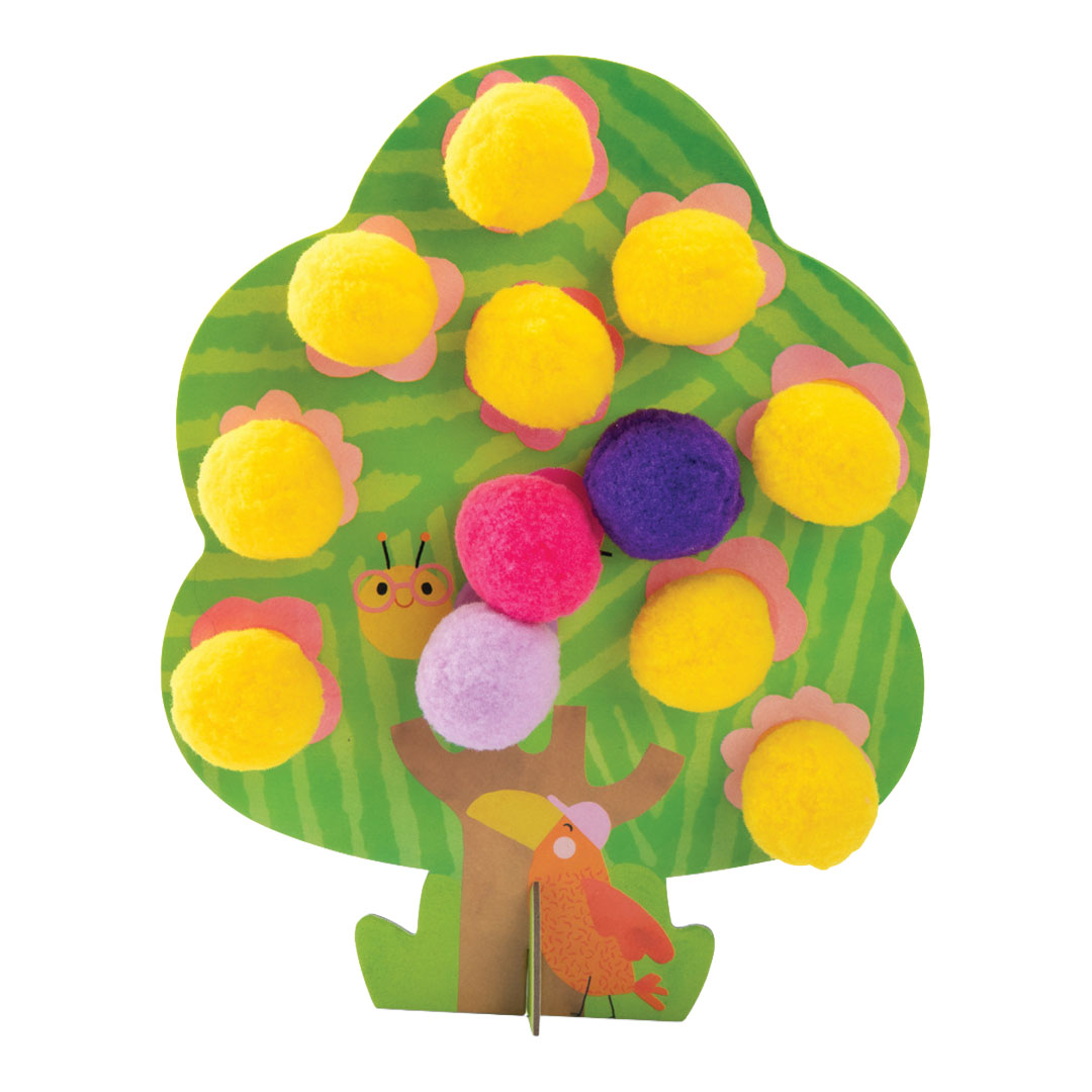 Een groen kartonnen boom van de knutselset met gele, roze en paarse pompoms en een vogelillustratie.
