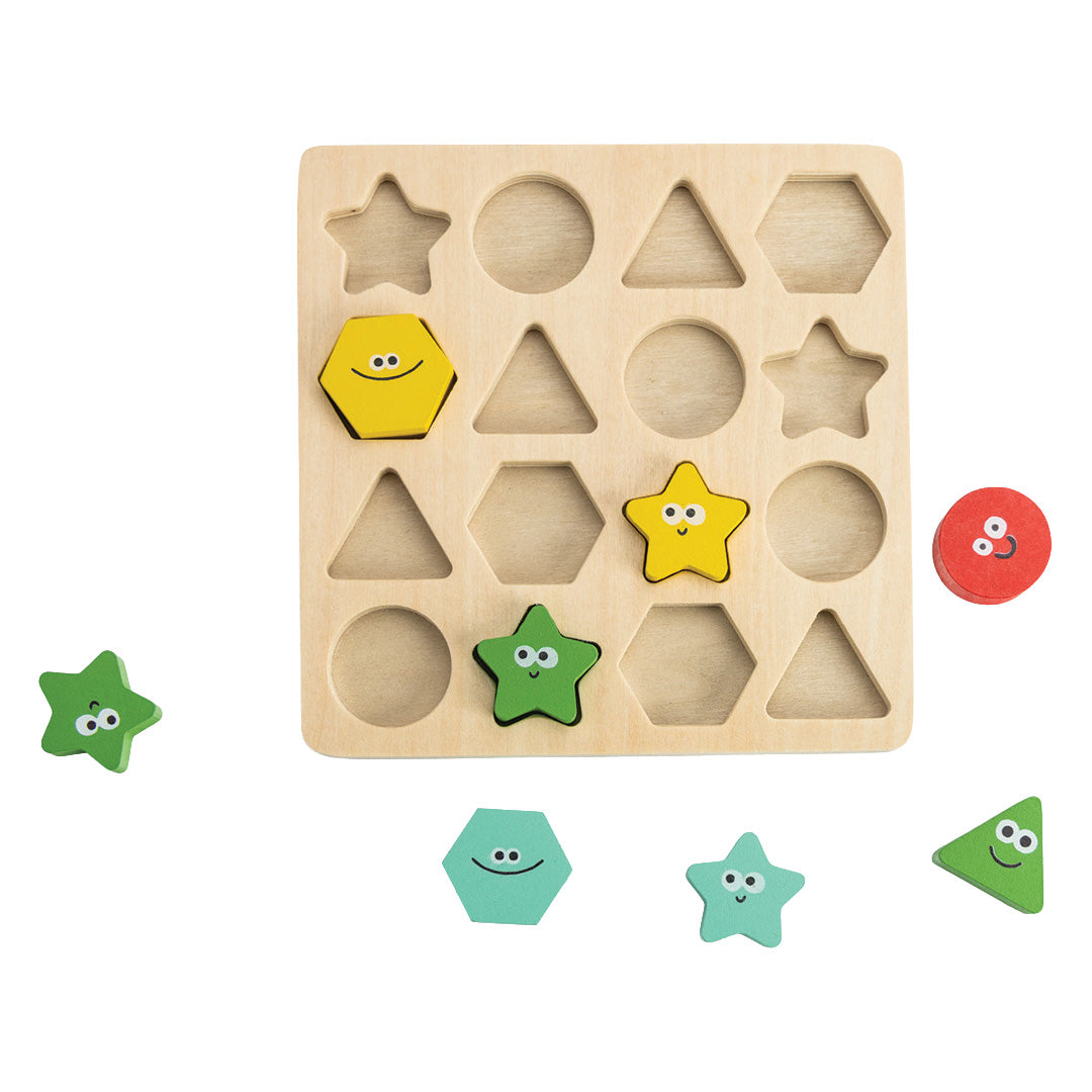 Houten puzzelbord met uitgesneden geometrische vormen en enkele gekleurde houten speelstukken met gezichtjes.