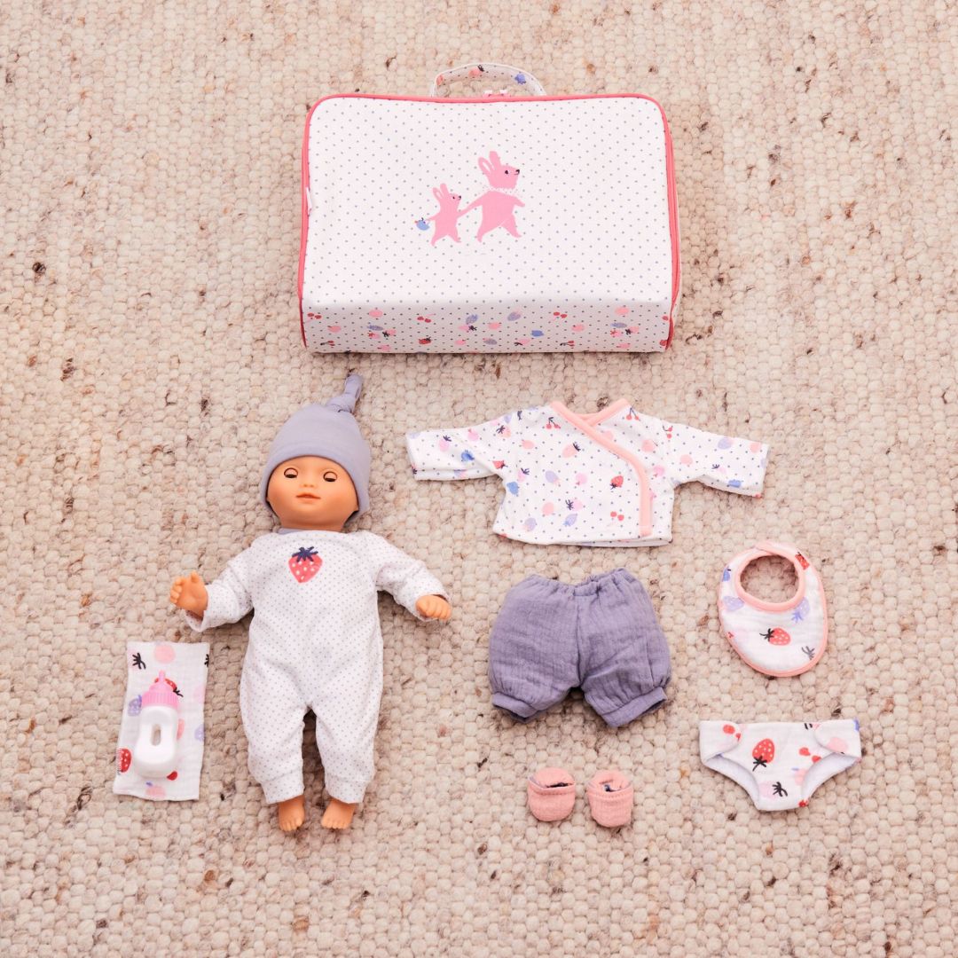Djeco Pomea babypop met kofferset en accessoires uitgestald