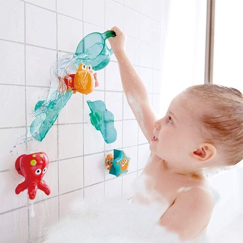Een kind speelt in bad met het Hape badspeelgoed ocean cascade aan de muur.