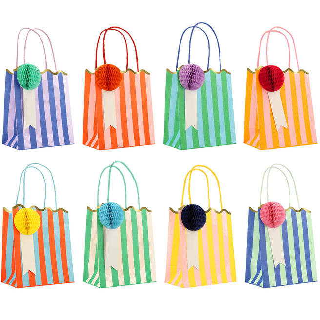 Acht Meri Meri gestreepte feesttasjes in diverse kleuren met honingraatdecoraties.