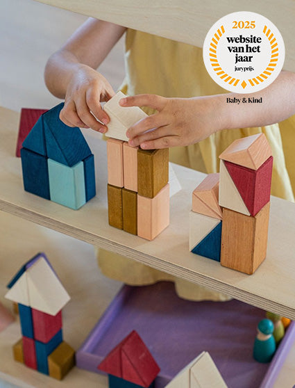 kind speelt met kleurrijke houten bouwblokken van Grimm's 