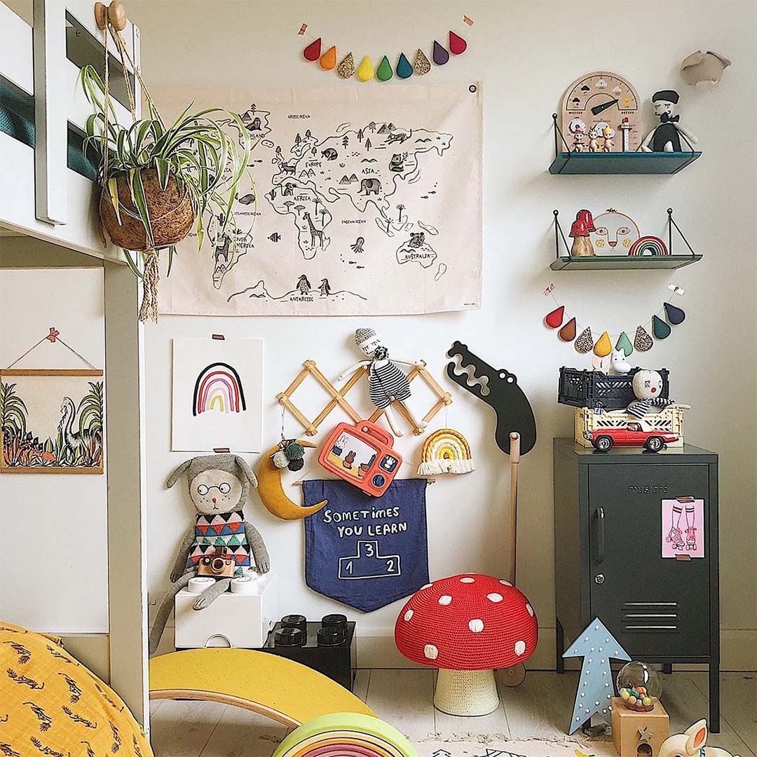 Het rose in April wandkleed met wereldkaart en dieren hangt in een kinderkamer vol speelgoed en decoratie.