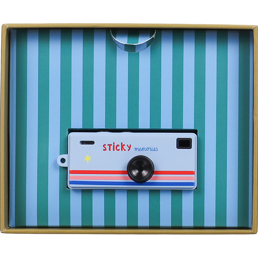 De verpakking van de Sticky Lemon mini kindercamera met het toestel zichtbaar in een blauw met groen gestreepte inleg.
